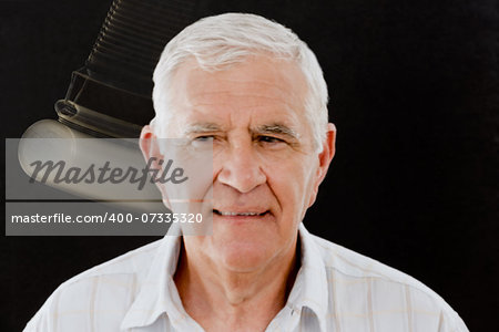 Senior man being hypnotized with pocket watch over black background