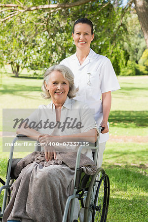 Portrait of a woman with her mature mother sitting in wheel chair at the park