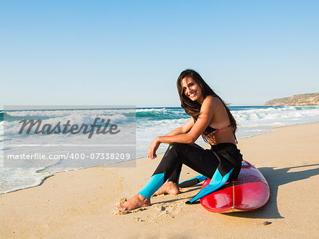 A beuatiful surfer girl making preparation for a surf session