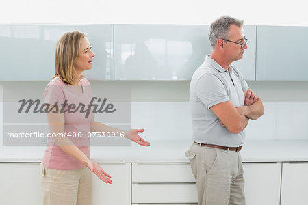Unhappy couple having an argument in the kitchen at home