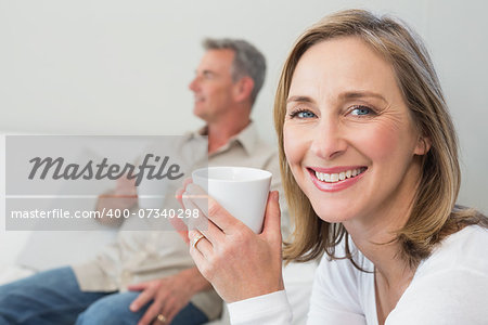 Relaxed couple with coffee cups in living room at home