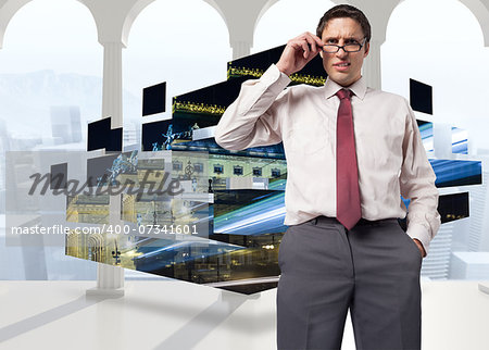 Thinking businessman touching his glasses against bright room with columns