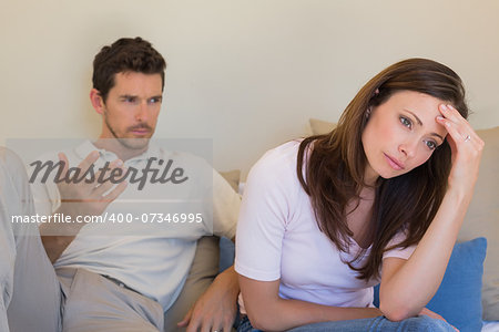 Unhappy couple having an argument in living room at home