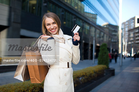 Smiling girl with shopping bags and credit card