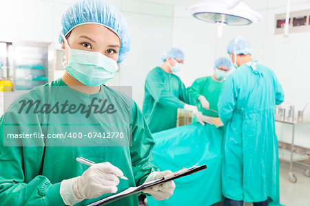 woman Surgeons writing medical record in operation room