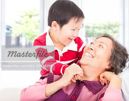 a boy playing with grandmother at home