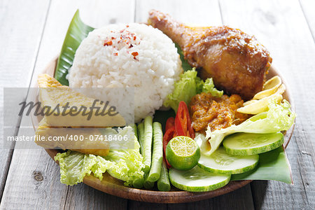 Famous traditional Indonesian food. Delicious nasi ayam penyet with sambal belacan.  Fresh hot with steam smoke.