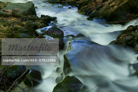 This is a mountain stream. Riversides are spread with fallen autumn leaves.