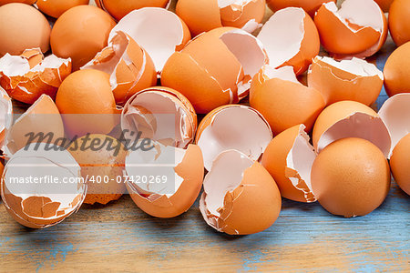 empty, broken,   brown eggshells against wooden background