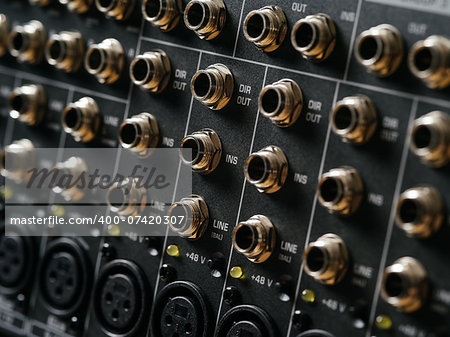 Macro photo of the rear panel of a recording studio mixer.