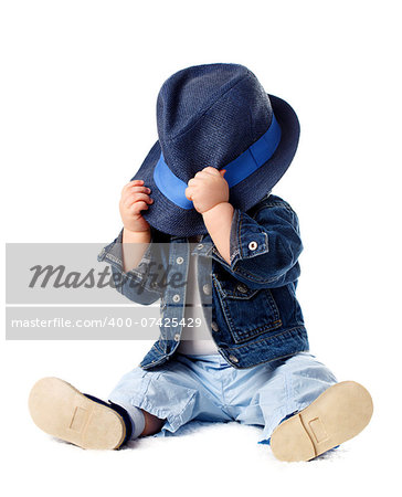 Shy baby boy hiding behind his hat