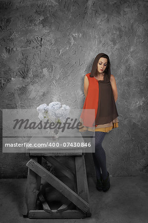 studio portrait of a beautiful woman with flowers on grunge background