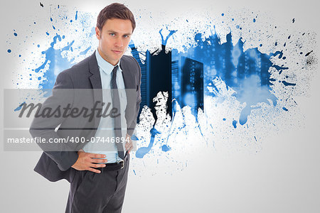 Serious businessman standing with hands on hips against splash on wall revealing server tower