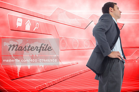 Stern businessman standing with hands on hips against futuristic technology interface