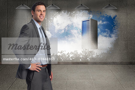 Smiling businessman with hand on hip against splash on wall revealing server tower