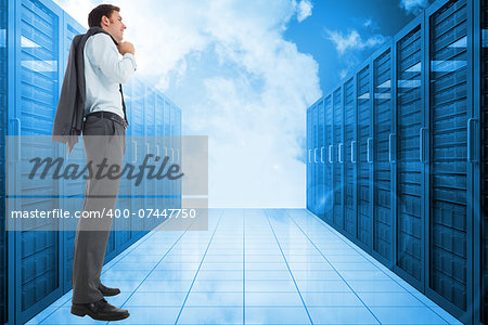 Smiling businessman holding his jacket against server hallway in the blue sky