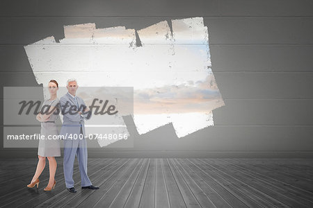 Serious businessman standing back to back with a woman  against display on wall showing bright sky