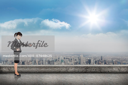 Focused businesswoman pointing against balcony overlooking city
