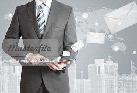 Man in suit holding tablet pc. Envelopes are emitted from the screen tablet. The concept of mailing