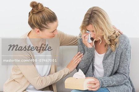 Crying woman talking to her therapist on the couch at therapy session