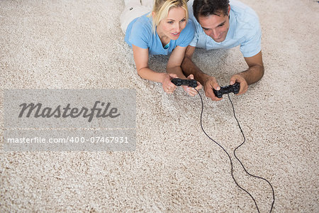 High angle view of a couple playing video games on area rug at home