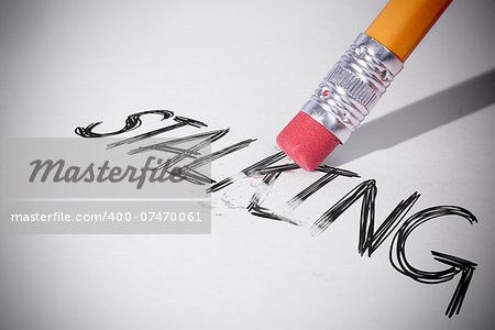 Pencil erasing the word stalking on paper