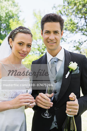 Portrait of newlywed couple having champagne in garden