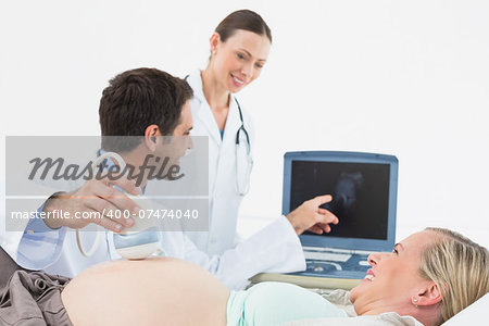Smiling pregnant blonde having an ultrasound scan at the hospital