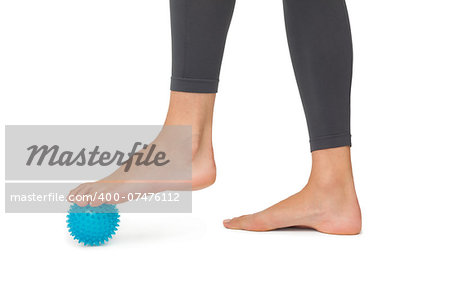 Close-up low section of woman standing over stress ball against white  background