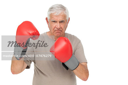 Portrait of a determined senior boxer standing over white background