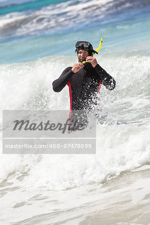 male diver with diving suit snorkel mask fins on the beach in Summer