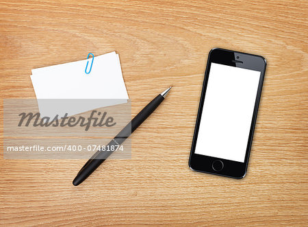 Business cards, pen and mobile phone on office table. Above view