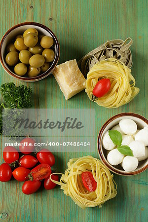 Italian still life - olives, mozzarella cheese, pasta, tomatoes