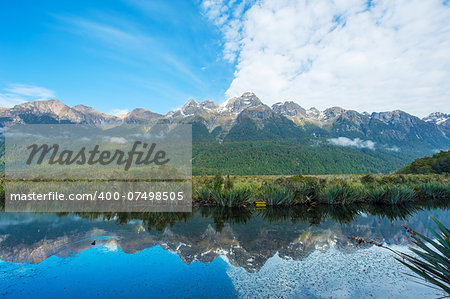 Mirror Lakes are a famous natural landmark omn the Milford Road in the Fiordland National Park. Snowy mountains are reflecting in a calm water. New Zealand