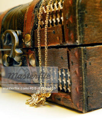 Detail of old treasure chest with gold chain. Isolated over white background.