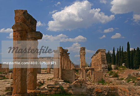 Hierapolis was an ancient Greco-Roman city and now its ruins are adjacent to modern Pamukkale, Turkey. Residuel arches against the blue sky background are eye-catching.