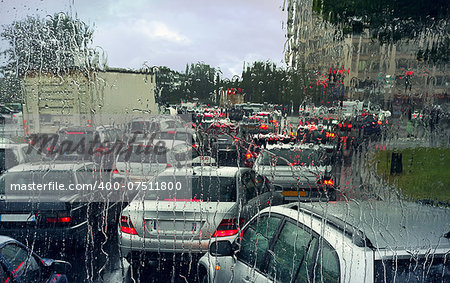 View through wet windshield on cars in a traffic jam on rainy day in Paris, France.