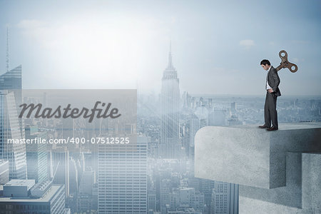 Wound up businessman with hands on hips against misty cityscape