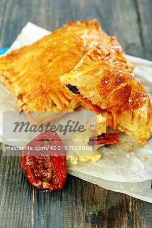 Puff pastry with cheese on wooden board.