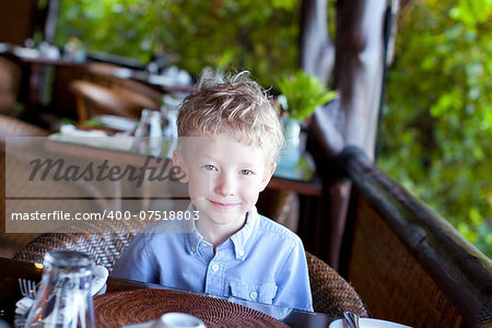 little cute boy waiting for his breakfast at the hotel