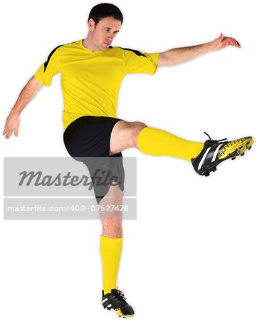Football player in yellow kicking on white background