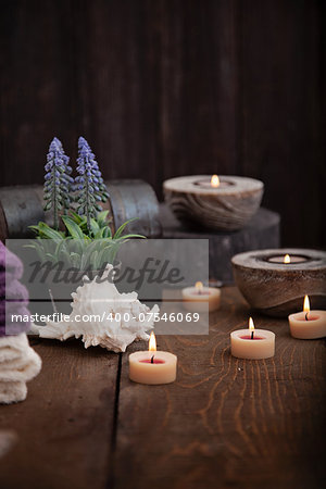 Spa and wellness setting with natural bath salt, candles, towels and flower. Wooden dayspa nature set