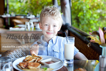 cheerful little boy ready for his breakfast at the resort