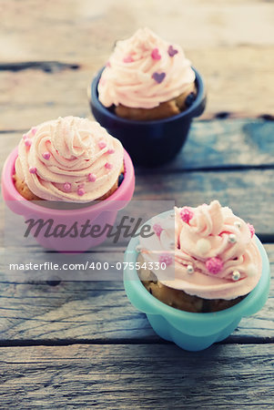 Photo of cute cupcakes on wooden background