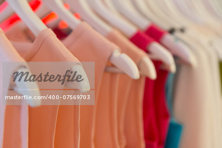 Closeup view of dresses on clothes hangers with very shallow depth of field.