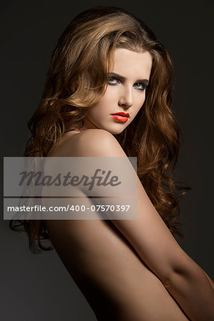 sexy girl with long wavy hair, naked shoulders and cool make-up. Charming portrait