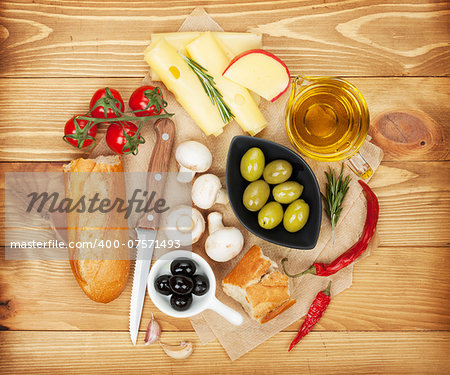 Olives, mushrooms, bread, vegetables and spices over cooking paper