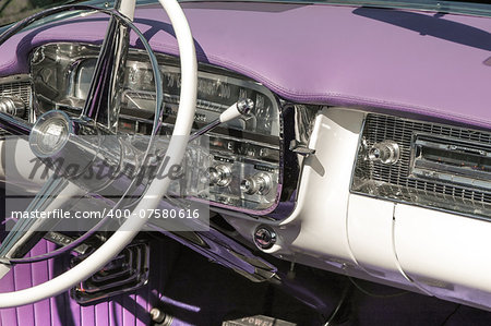 dashboard and steering wheel on a classic car, circa 1950