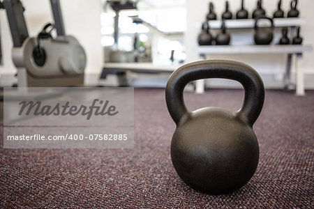 Black kettlebell on the weights room floor at the gym