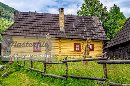 View of traditional village house and wooded statues, Vlkolinec, Slovakia